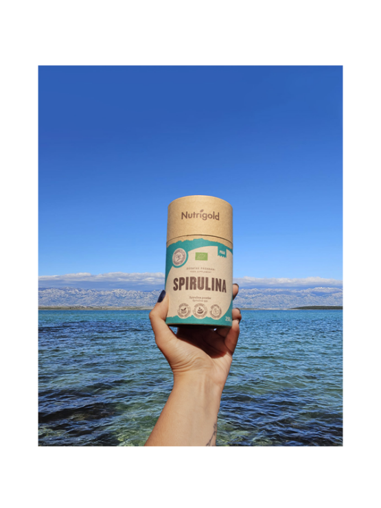 Nutrigold organic spirulina powder in a green cylindrical cardboard packaging of 250g